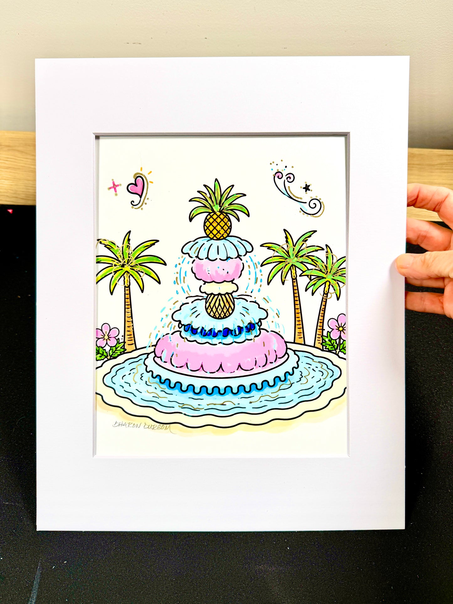 Framed Pineapple Fountain artist embellished print displayed in a white mat.