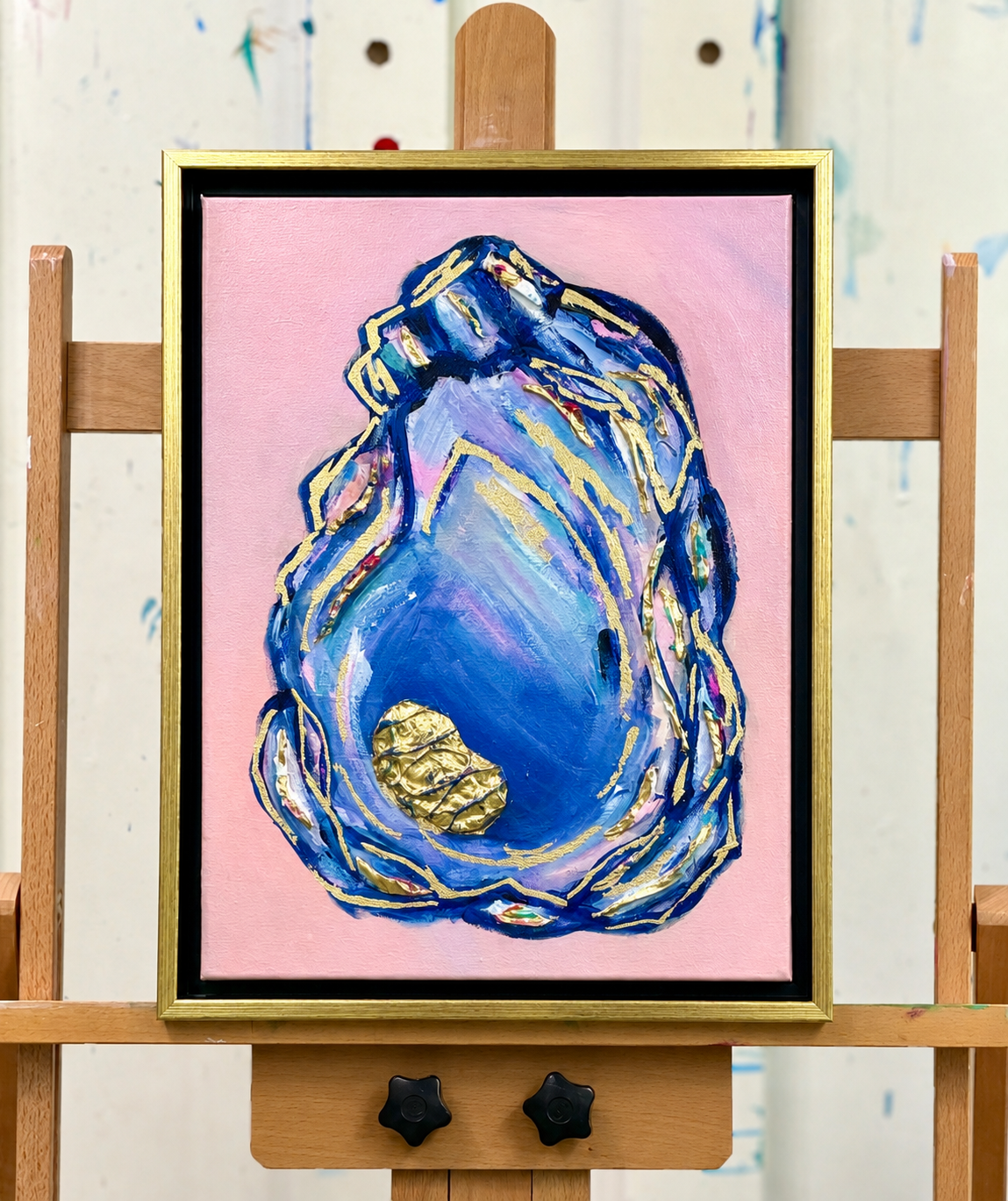 Original coastal oyster painting with layered blue and blush tones, metallic gold accents, and textured acrylic on canvas in a black and gold floater frame.